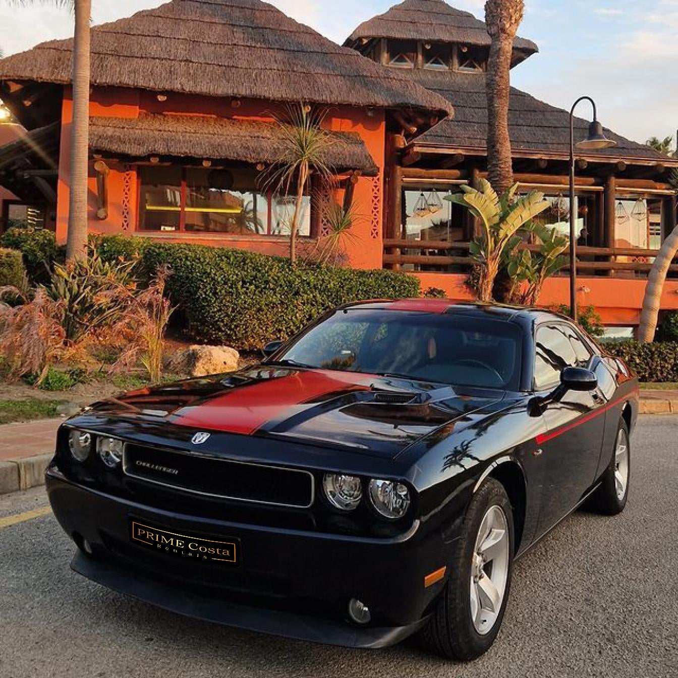 Black and red Dodge Challenger for rent in Marbella – automatic American muscle sedan.