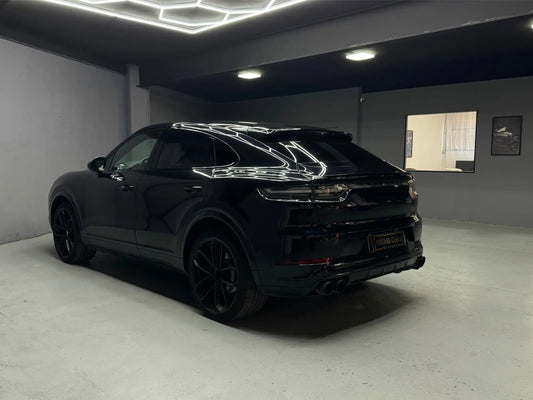 Porsche Cayenne black SUV rear view in garage car hire Alicante