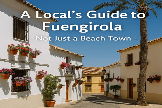 Sunny village street in Fuengirola, Spain, with whitewashed buildings, potted flowers, and a palm tree — highlighting the town’s charm beyond the beach.