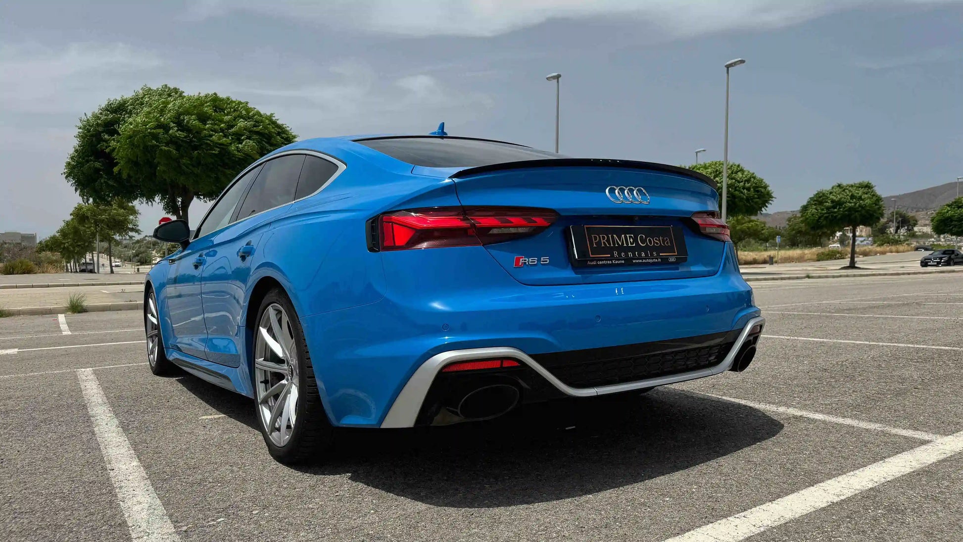 2020 Blue Audi RS5 rear left side in parking space with trees in Spain
