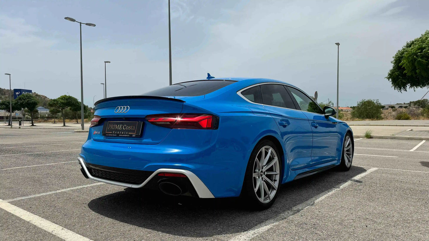 2020 Blue Audi RS5 back right side in empty parking space shiny day in spain