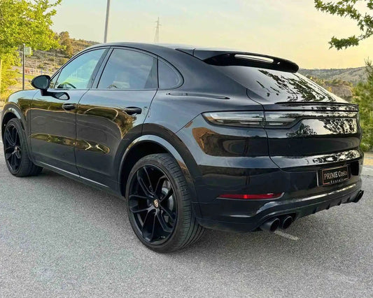 2020 Black Porsche Cayenne back left side pictured on street surrounded by trees, in Spain