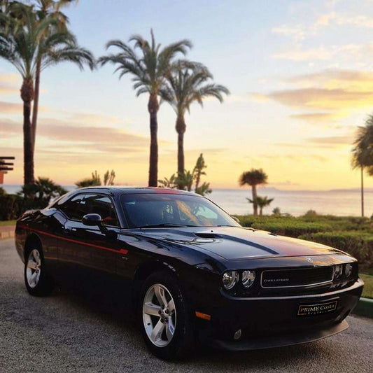 Black and red Dodge Challenger for rent in Marbella – automatic American muscle sedan.
