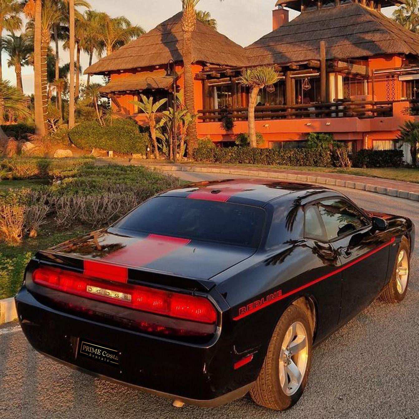 Black and red Dodge Challenger for rent in Marbella – automatic American muscle sedan.
