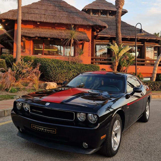 Black and red Dodge Challenger for rent in Marbella – automatic American muscle sedan.
