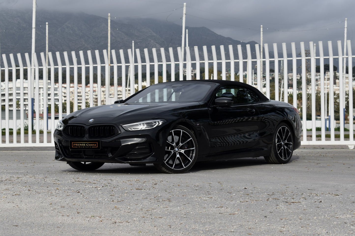 Black 2022 BMW 840d xDrive Cabrio convertible parked in Marbella, available for luxury rental.

