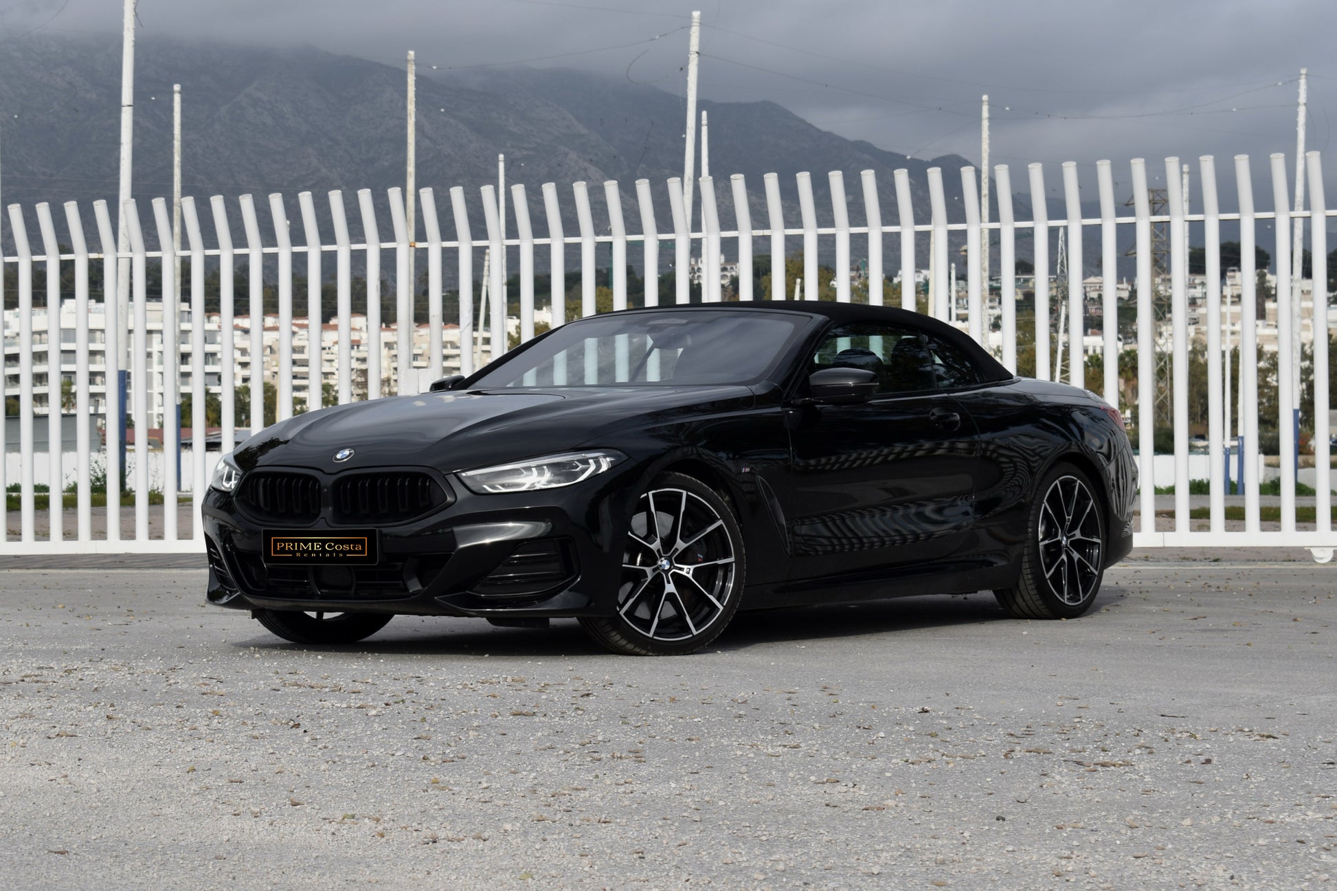 Black 2022 BMW 840d xDrive Cabrio convertible parked in Marbella, available for luxury rental.
