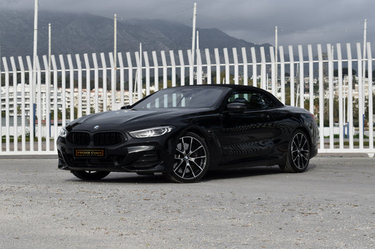 Black 2022 BMW 840d xDrive Cabrio convertible parked in Marbella, available for luxury rental.
