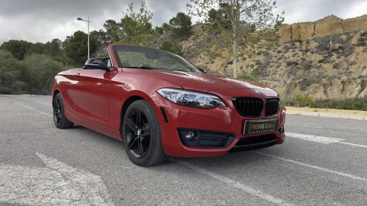 Red BMW 2 Series Convertible front right side on the street in Spain surrounded by trees