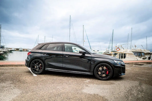 Black Audi RS3 right side pictures in parking near seat and ship port