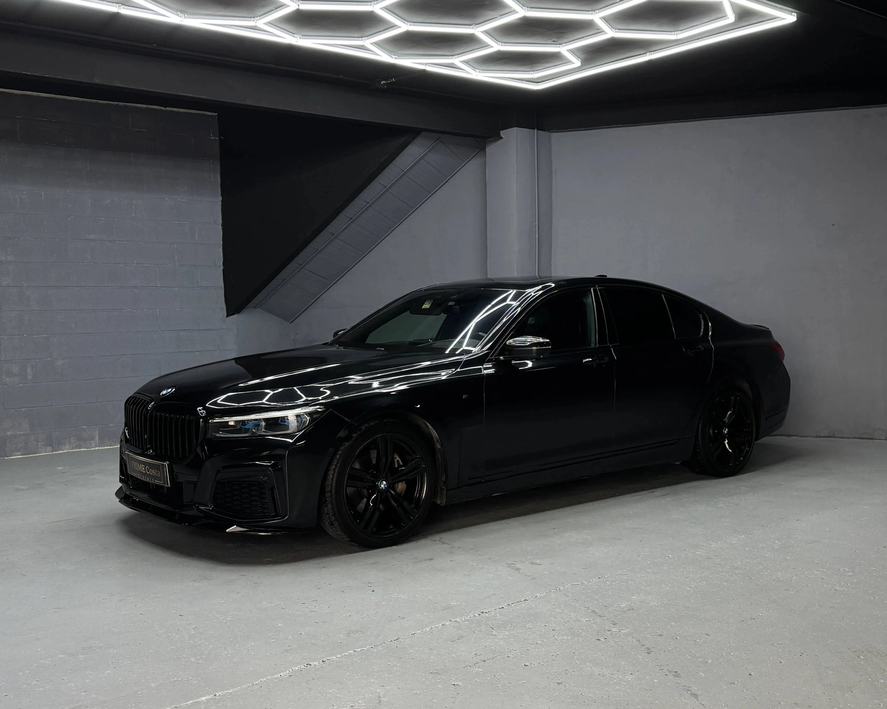 BMW 730d M Sport luxury sedan available for rental, photographed in a premium indoor showroom