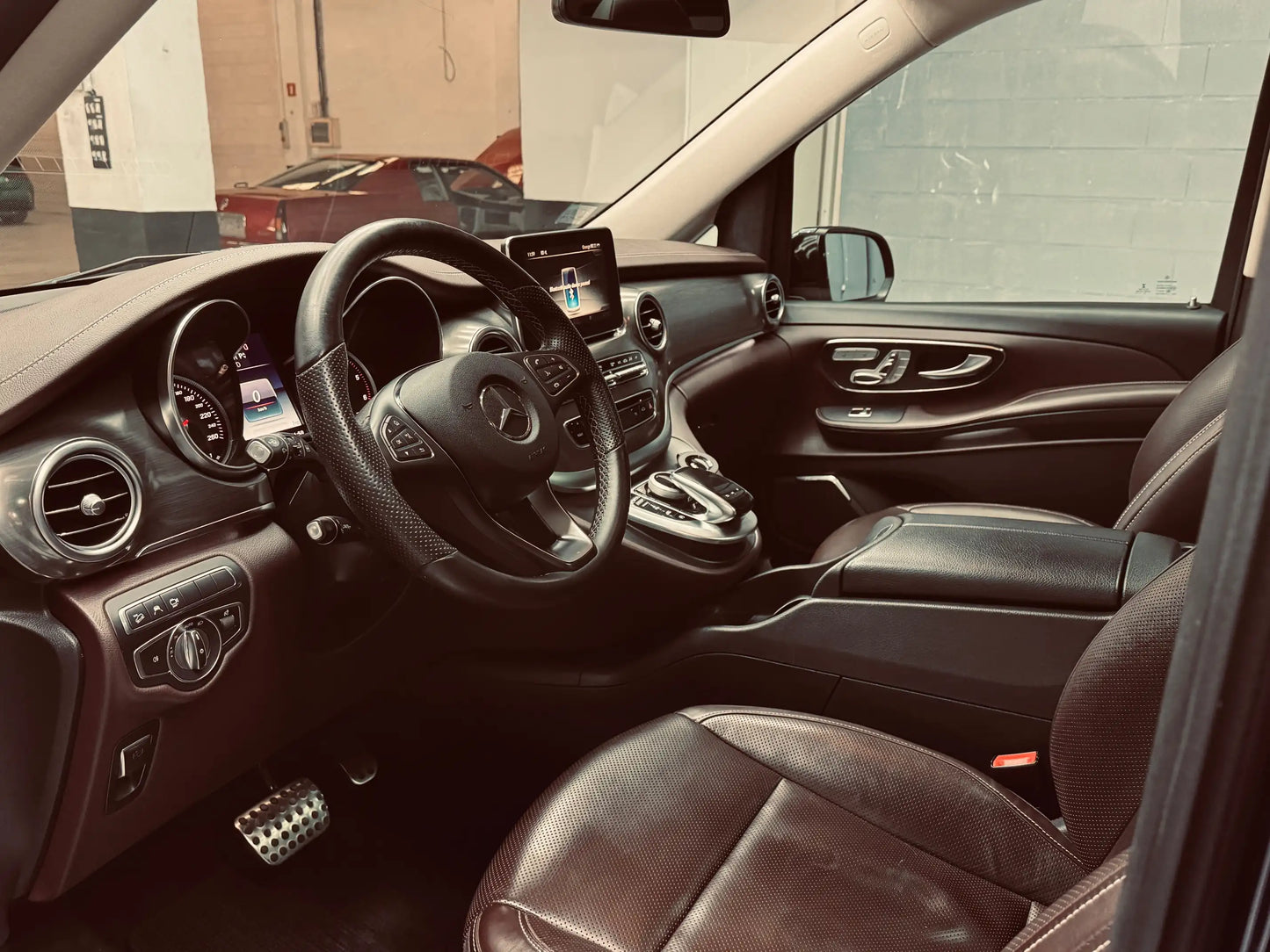 Interior of Mercedes V-Class V250 showing driver cockpit, leather seats, and infotainment system
